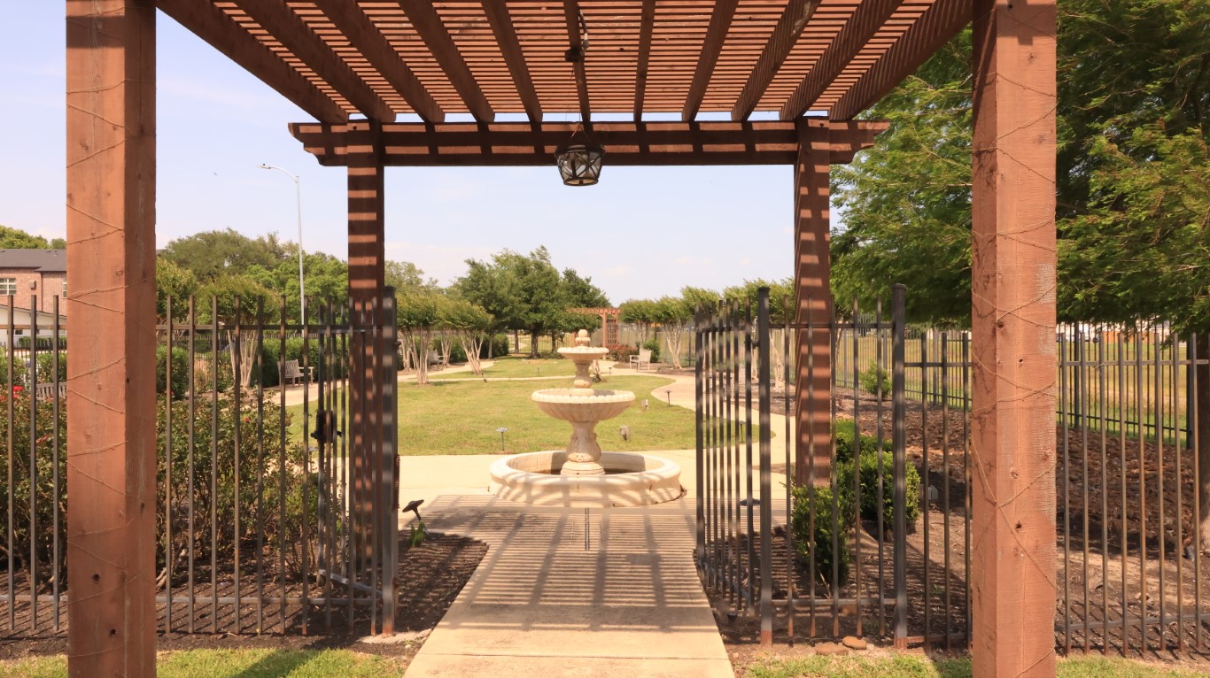 Pathway leading through a landscaped outdoor space with a fountain