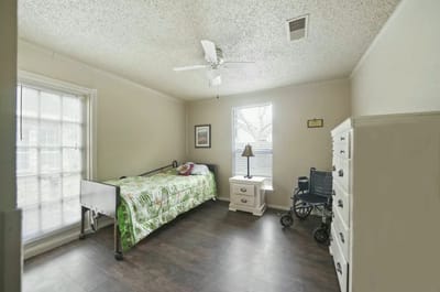 Cozy private resident room with a bed and wheelchair