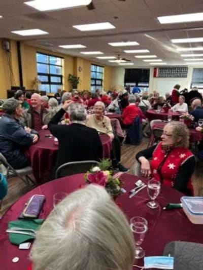 Residents socializing at tables during a festive event