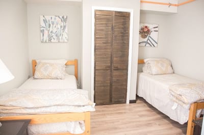 Brightly lit twin bedroom with wooden furniture