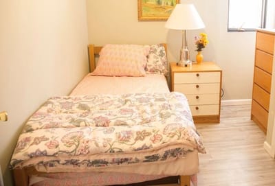 A cozy resident room with a bed and nightstand