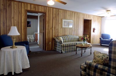 Bea’s Hive Assisted Living III, assisted living in Bowie, MD — Cozy living area with plaid sofas and lamps