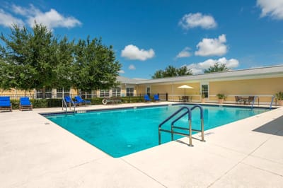 Outdoor pool area with seating and umbrellas