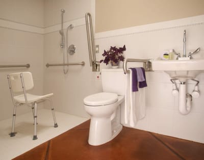 Accessible bathroom with safety features and a chair