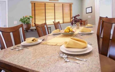Dining setup with plates and fruit centerpiece in a bright room