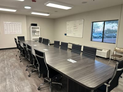 A spacious meeting room with chairs and a large table