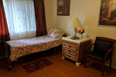 Cozy resident room with bed and table lamp