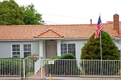 Exterior view of a facility with a flag and garden