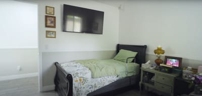 A cozy resident room with a bed and TV.