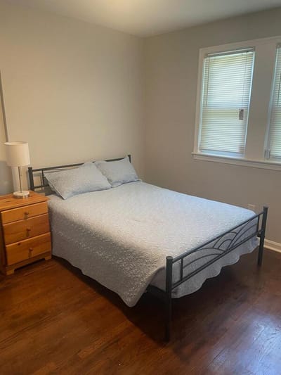 Bedroom with a bed and wooden dresser