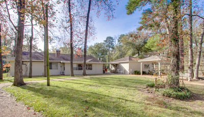 Outdoor view of assisted living facility with garden and trees
