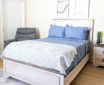 A private resident room with a bed and chair