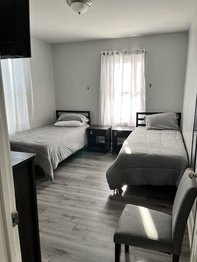 A shared room with two beds and a chair