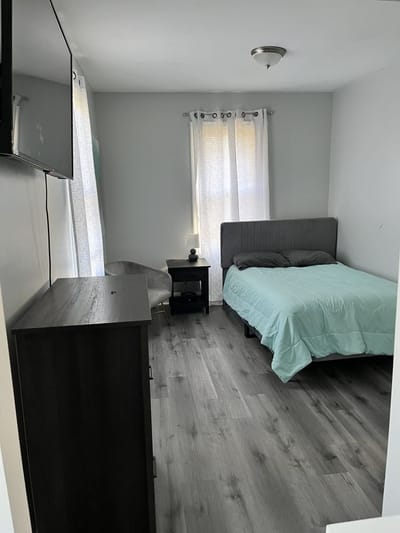 A private resident room with a bed and dresser