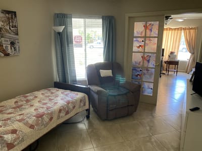 Cozy resident room with seating and quilted bed