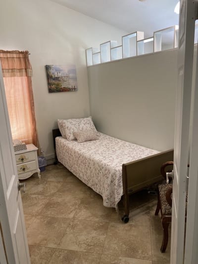 A cozy resident room with floral bedding and natural light