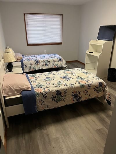 A private resident room with two beds and furniture