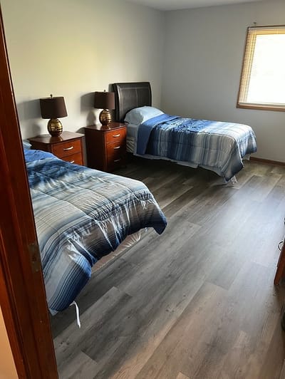 Two twin beds in a well-lit resident room