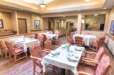 Dining area set up for a meal with flowers on tables