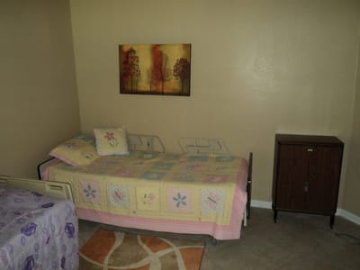 Cozy interior of a resident's room with a bed and artwork