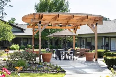 Outdoor seating area with shaded pergola in a garden