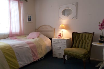 Cozy bedroom setup with a bed, chair, and lamp