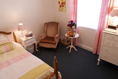 Cozy resident room with a bed and armchair