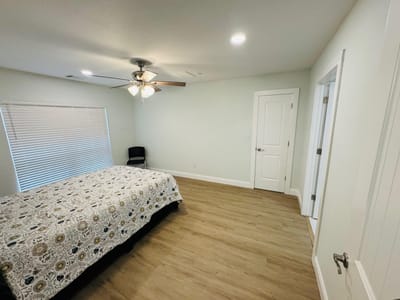 Bright interior of a resident room with a bed and chair