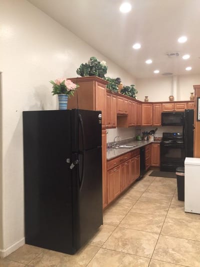 Interior view of a kitchen with cabinets and a refrigerator