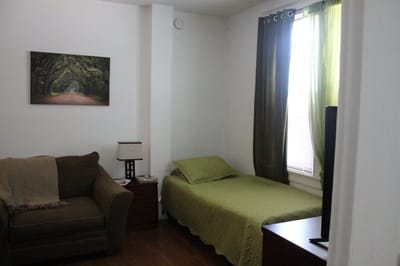 A cozy resident room with a bed and seating area