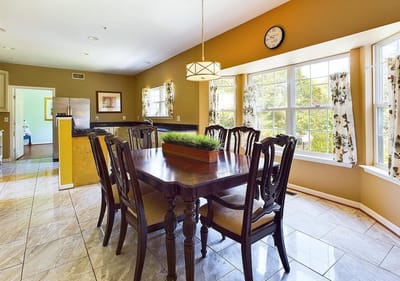 A well-lit dining room with wooden table and chairs