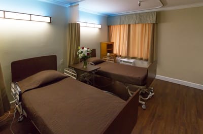 A cozy resident room with two beds and flowers