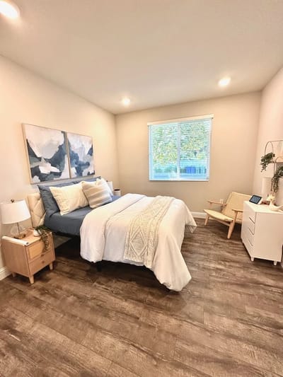 Bright private bedroom with large window and decor