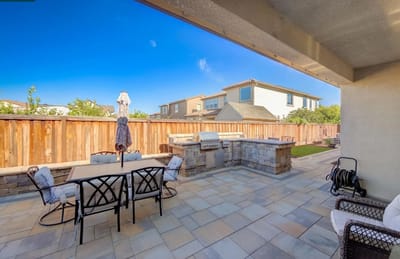 Outdoor patio area with seating and a grill
