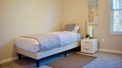 A private resident room with a bed and nightstand