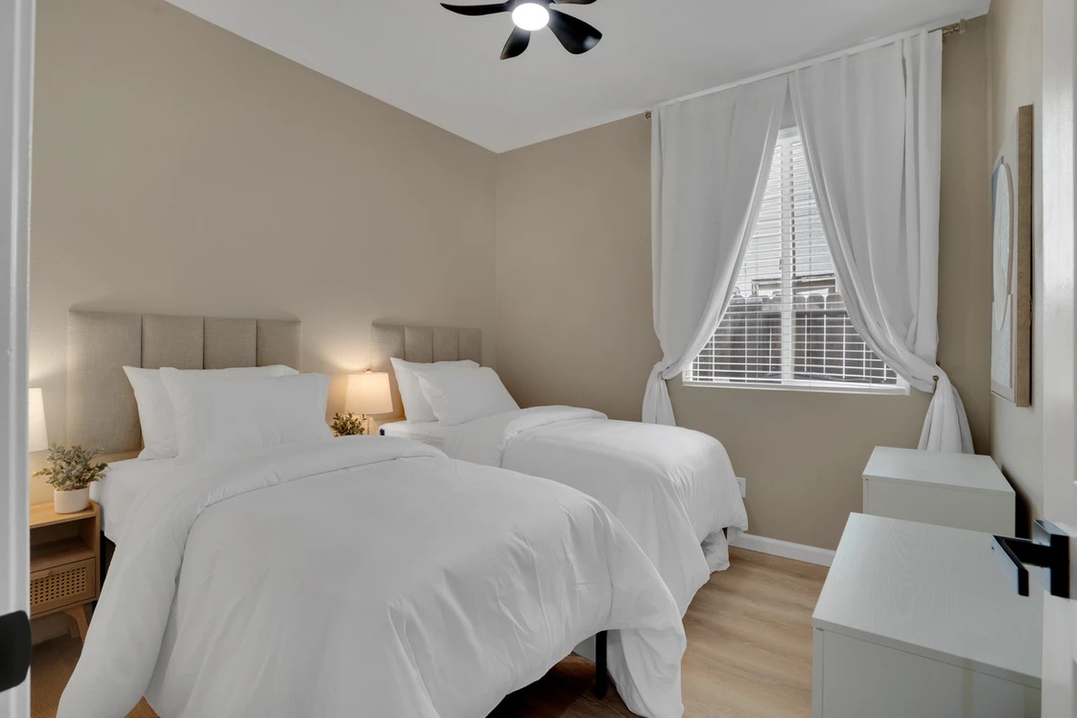 A well-lit shared resident room with two beds