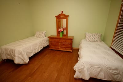 A cozy shared resident room with two beds and a dresser