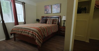 Cozy resident room with a striped bedspread and artwork