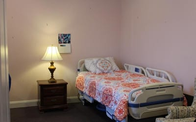 Cozy private room with a hospital bed and lamp