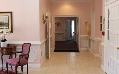 Bright interior hallway with pink walls and a statue