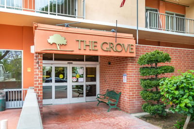 Entrance of The Grove Care and Wellness with greenery