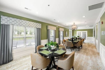 Dining room with tables and green walls in a senior living facility