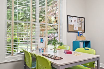 Bright activity room with art supplies and view of garden