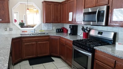 Interior view of a facility kitchen with cabinets and appliances.