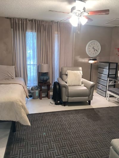 A cozy resident room with a bed and chair