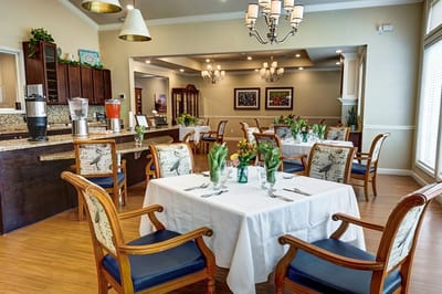 Dining room with neatly set tables and fresh flowers