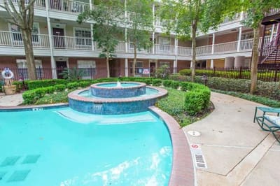 Outdoor pool area with a fountain and garden