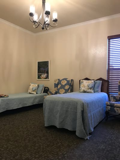 Cozy shared resident room with blue bedding and floral decor
