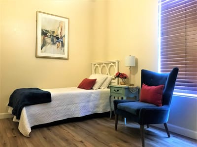 Cozy interior of a resident's room with bed and chair