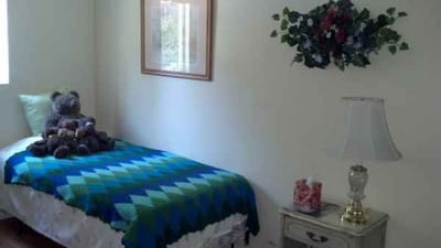Cozy resident room with teddy bears and a quilt